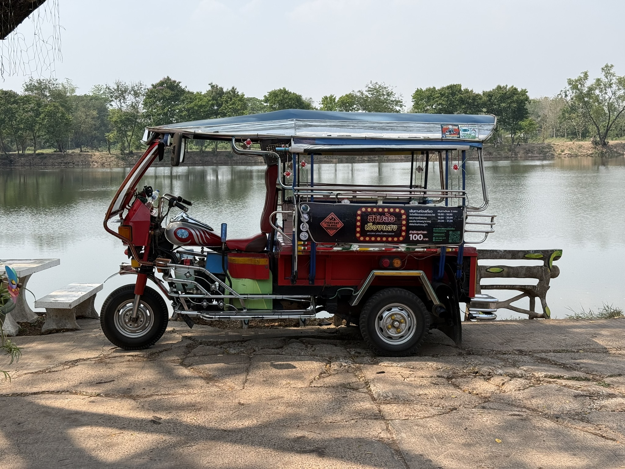 Addy standing next to his colourful tuk tuk in Nong Khai Thailand